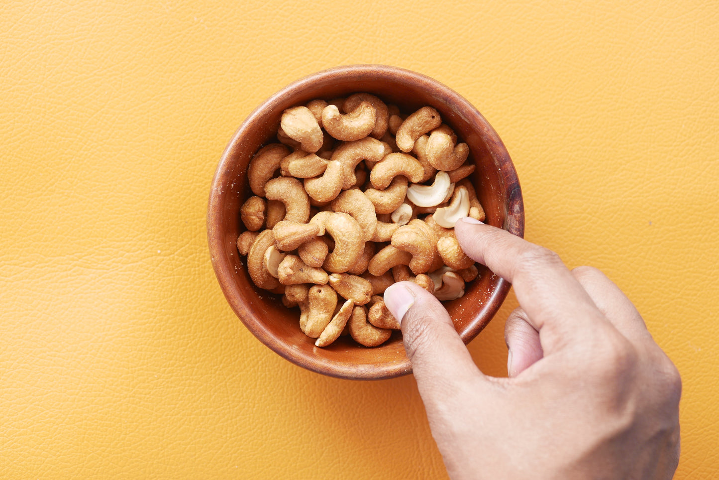 hand picking up cashews